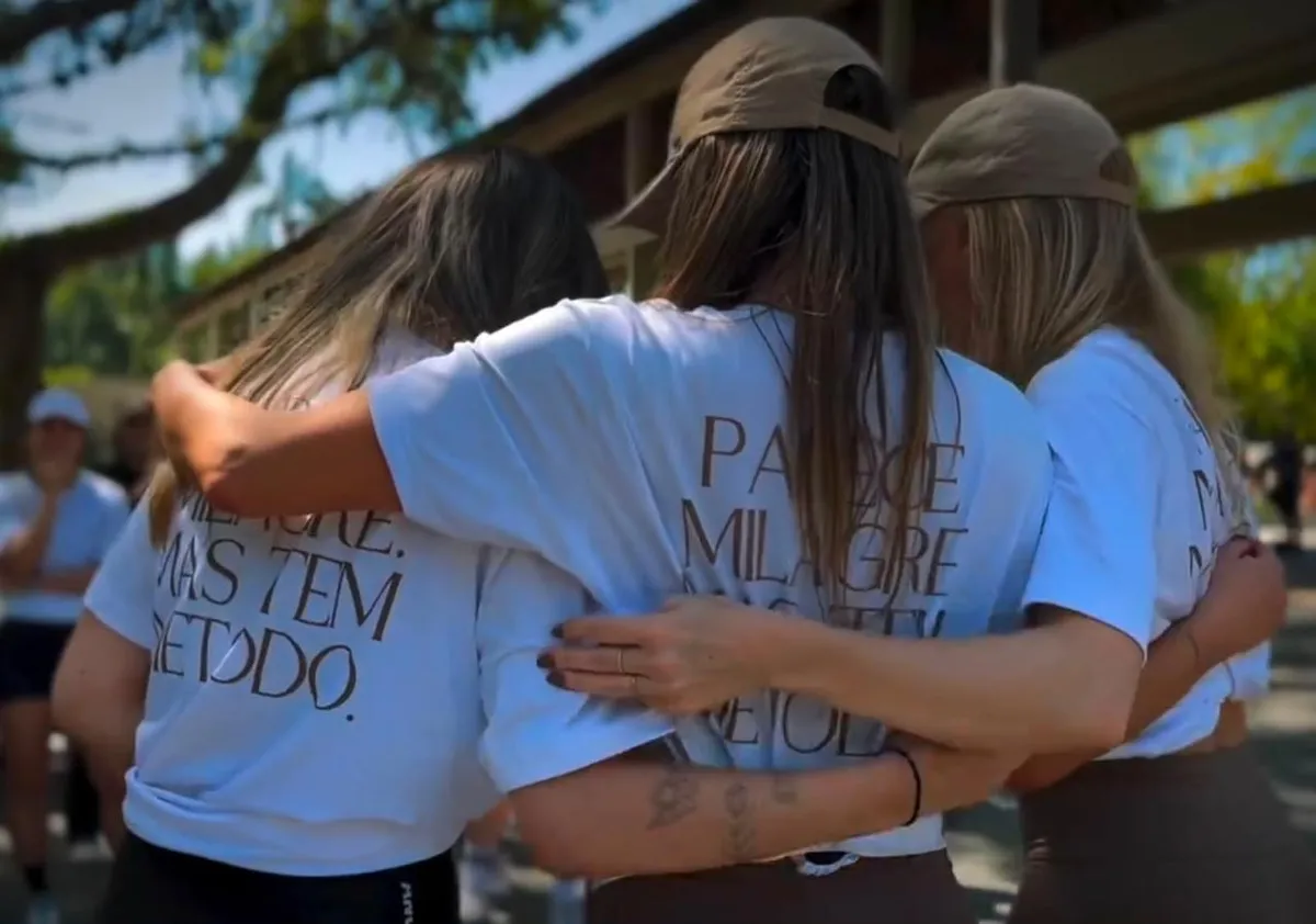 Participantes abraçadas vestindo as camisetas Parece Milagre Mas Tem Método
